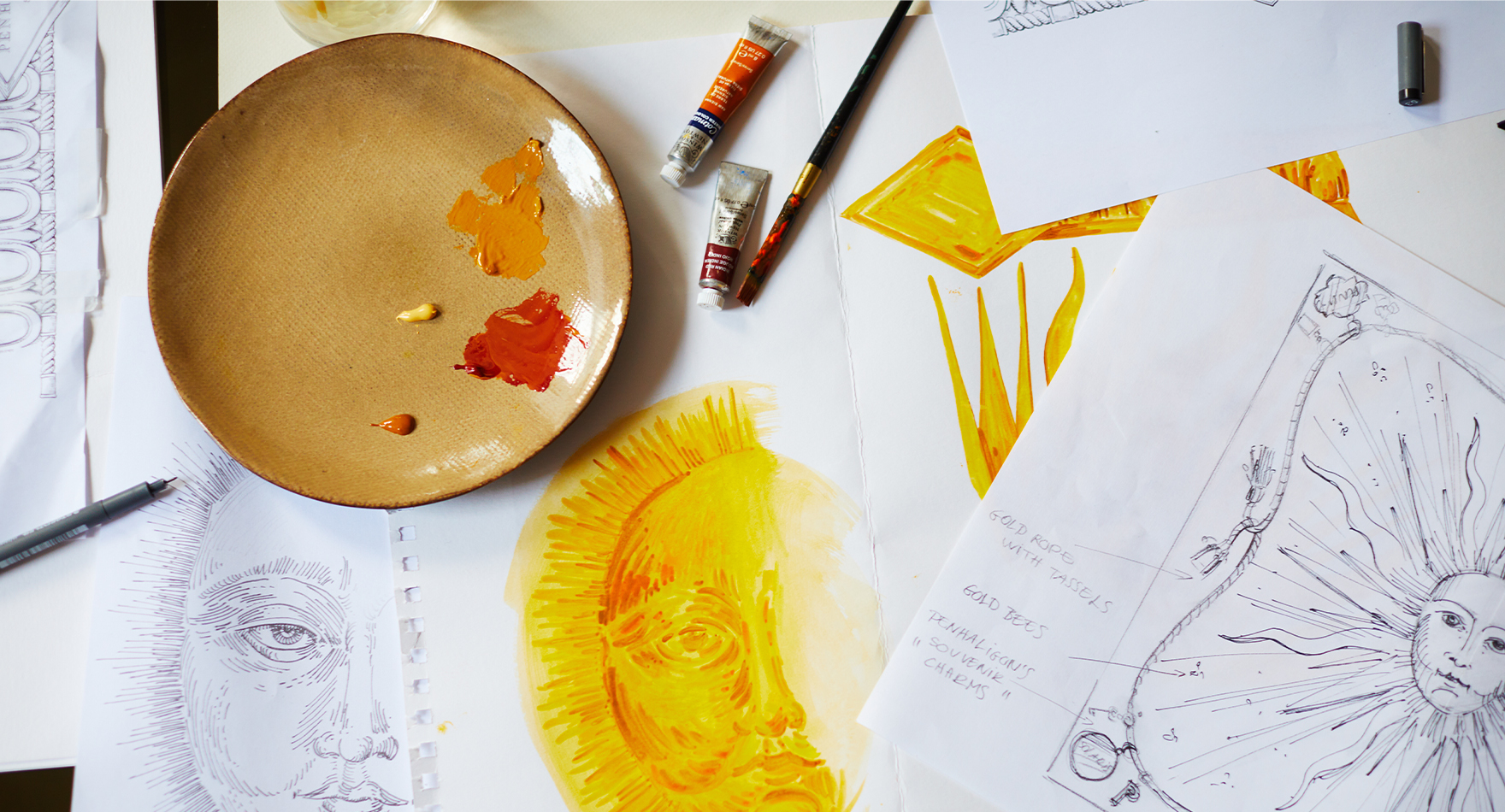 paintings, sketches and plate with paint on table